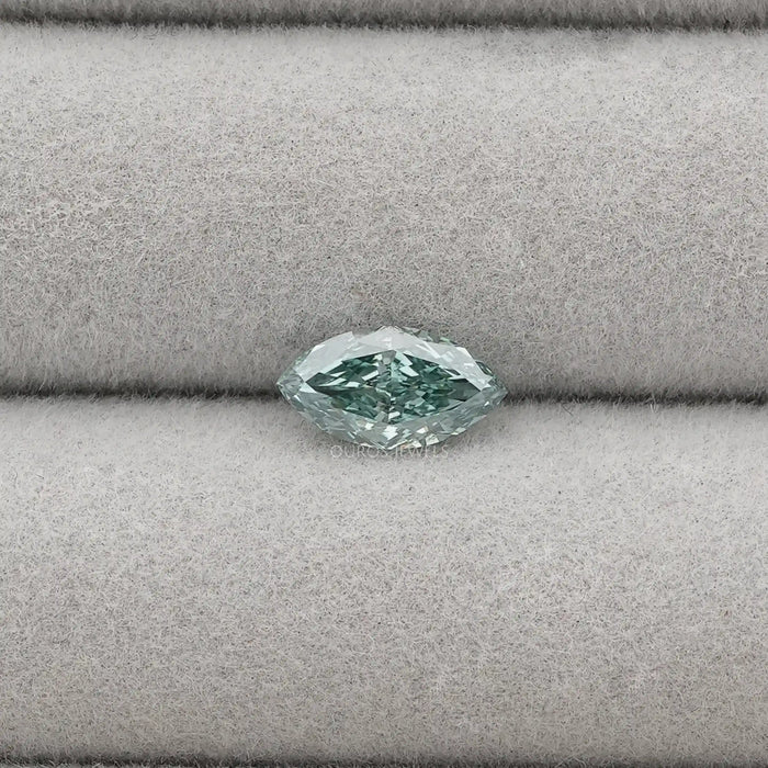 1.23 Carat Green Marquise Cut Loose Diamond placed on a light gray fabric background.