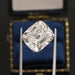 10 Carat IGI Certified Old Mine Cushion Cut Diamond held by tweezers with a blue and gold background.