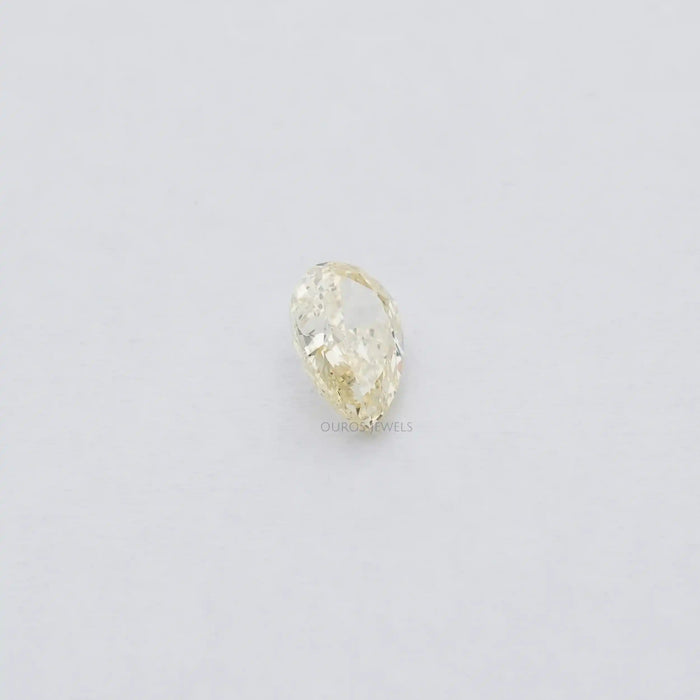 2.17 Carat Fancy Yellow Pear Cut Loose Diamond displayed on the soft plain white surface.