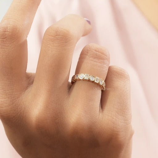 A women wearing Round Cut Lab Diamond Eternity Wedding Band in ring finger with light pink background.