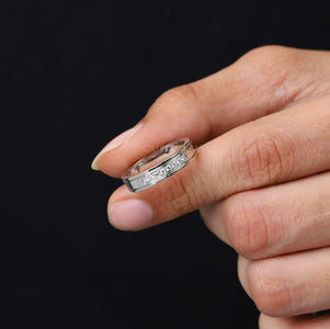 A Men Holding 8 Stone Round Diamond Men's Wedding Band with dark background.